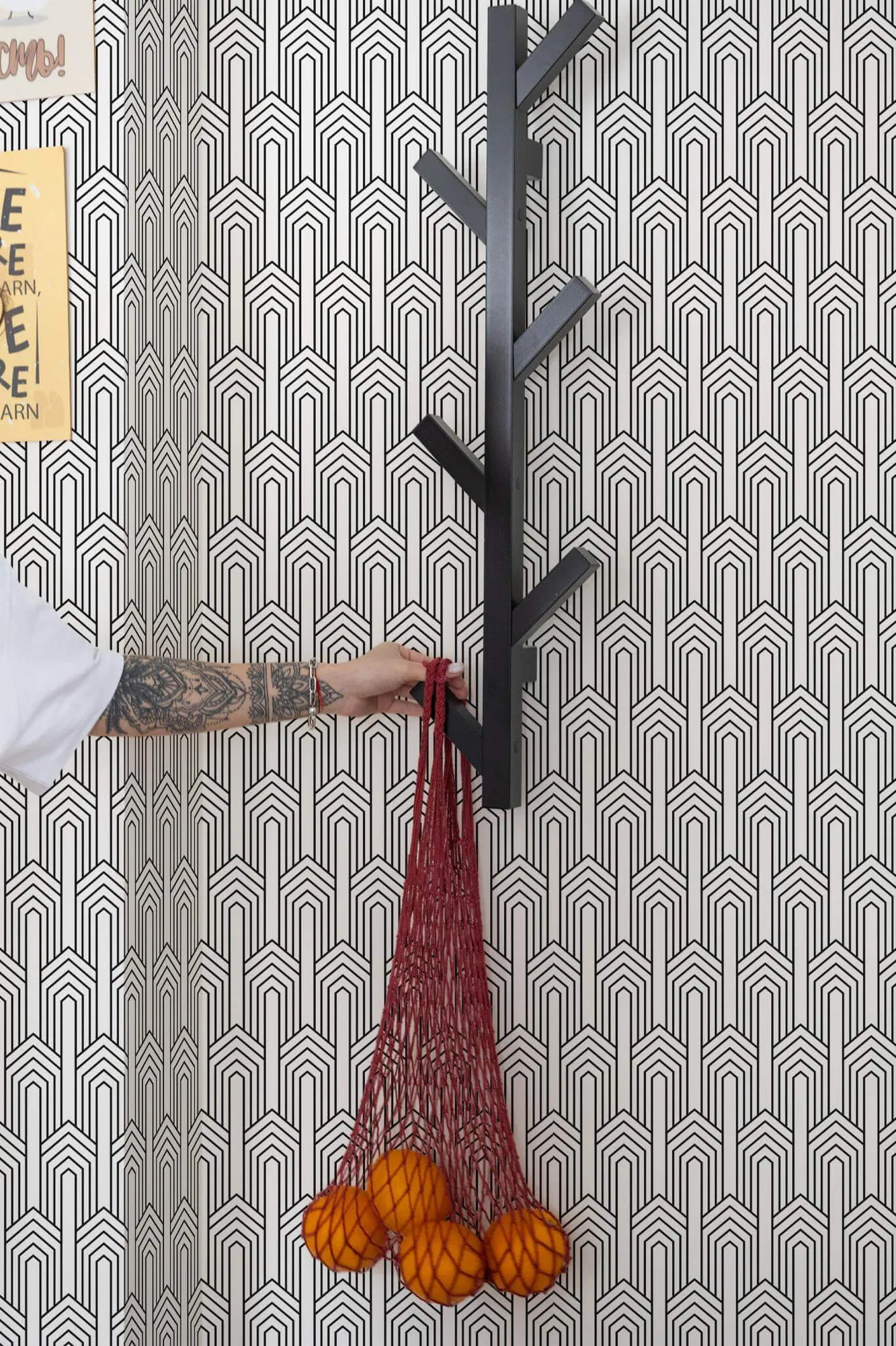 Art Deco arch wallpaper in a room setting: nested black arches form a crisp geometric repeat on white
