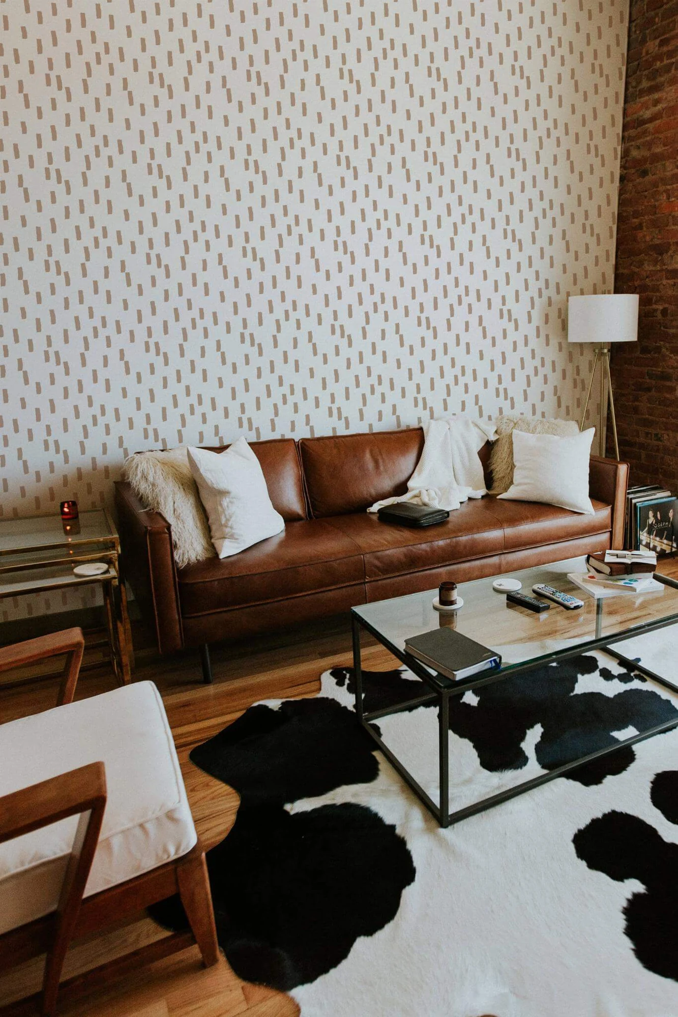 Beige brush stroke lines wallpaper in a room setting: small beige brush marks on white. A printed pattern, not plaster or linen