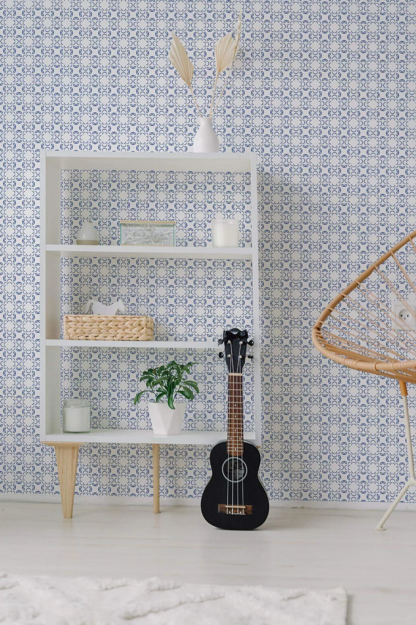 Blue and white geometric floral wallpaper in a room setting: fine blue floral loops form a small lattice on white