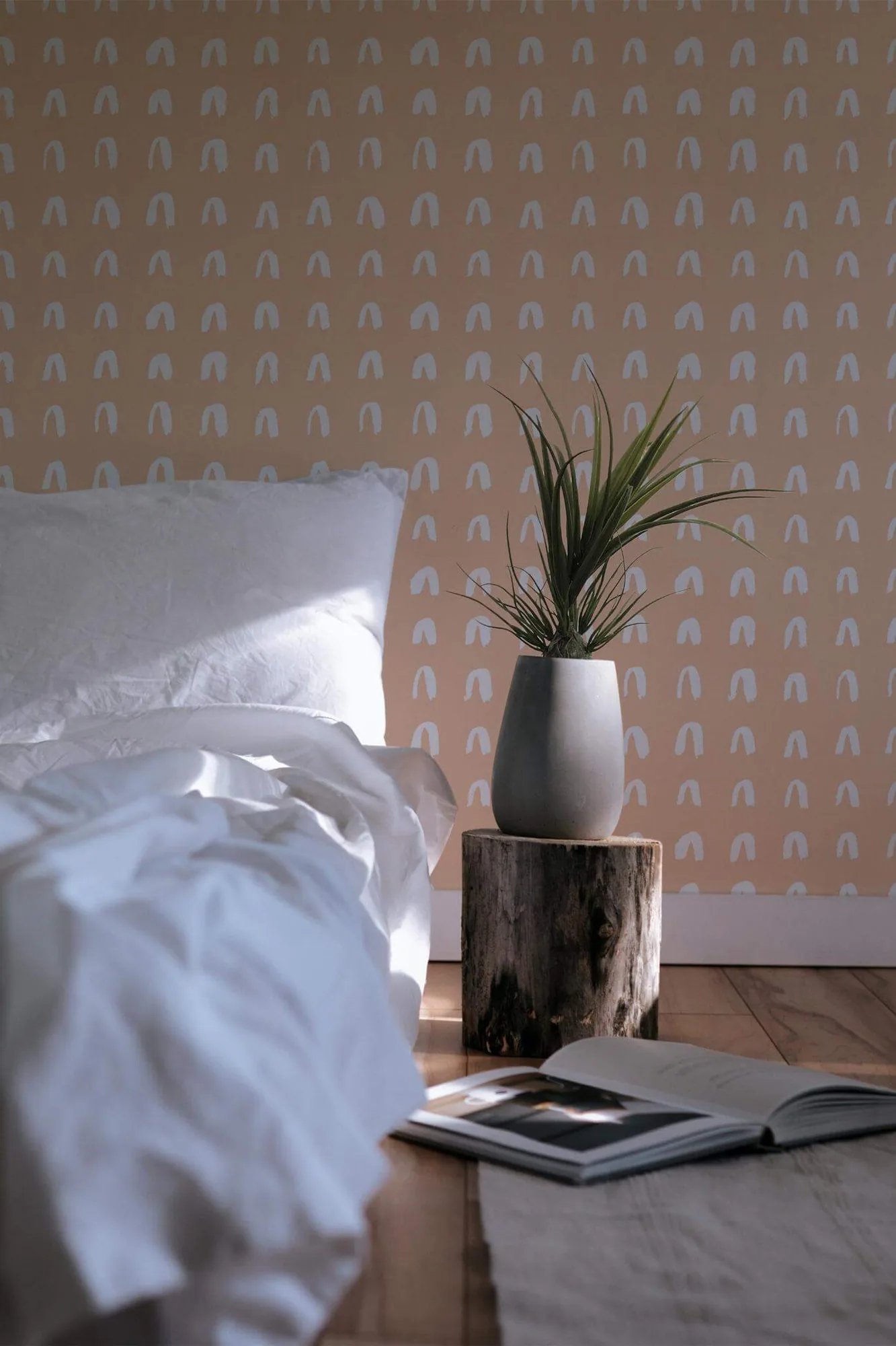Brush stroke arch wallpaper in a room setting: small white brush-stroke arches repeat across a warm peach ground