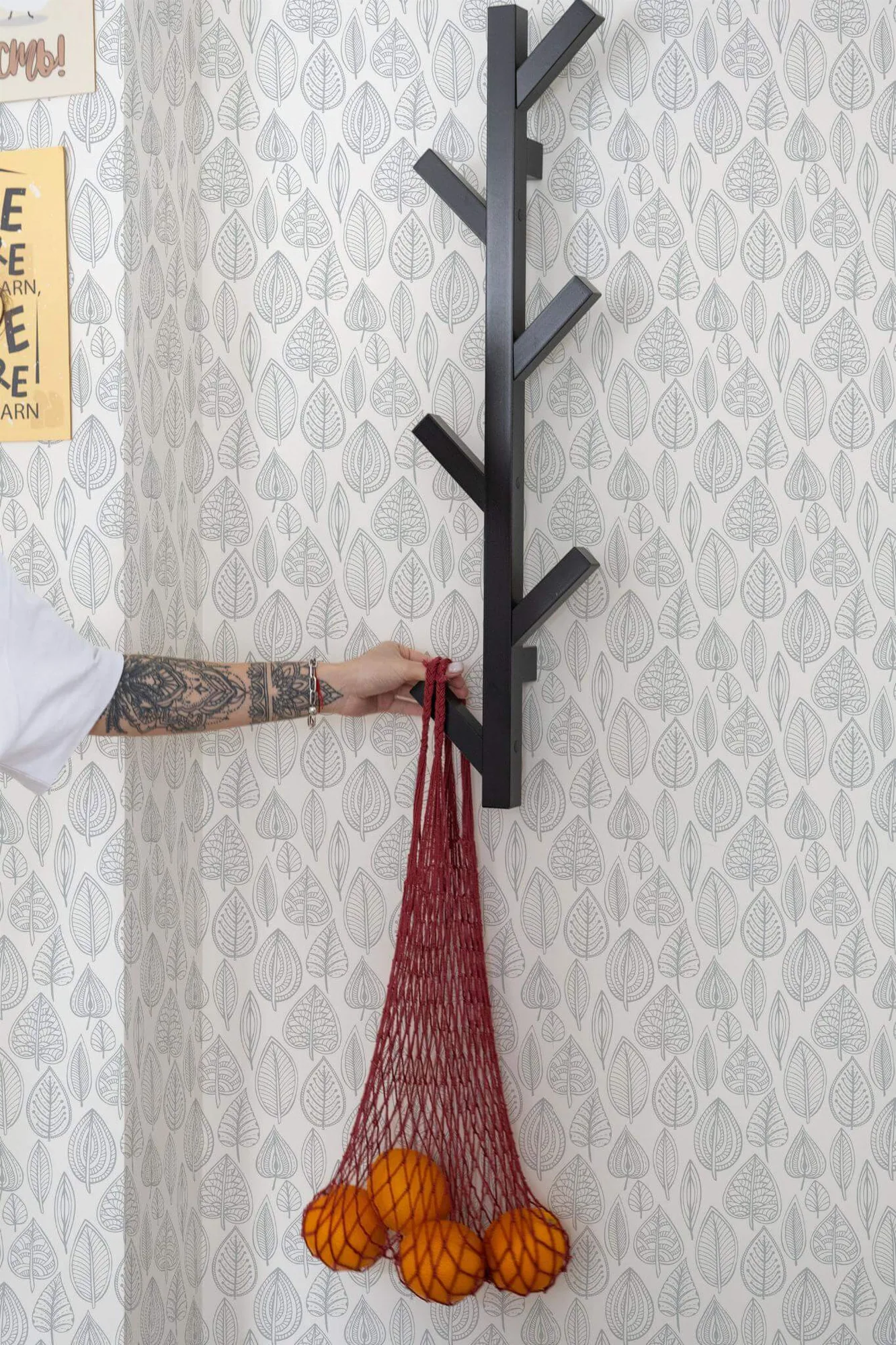 Gray Scandi leaf wallpaper in a room setting: fine gray leaf outlines arranged in vertical rows on white