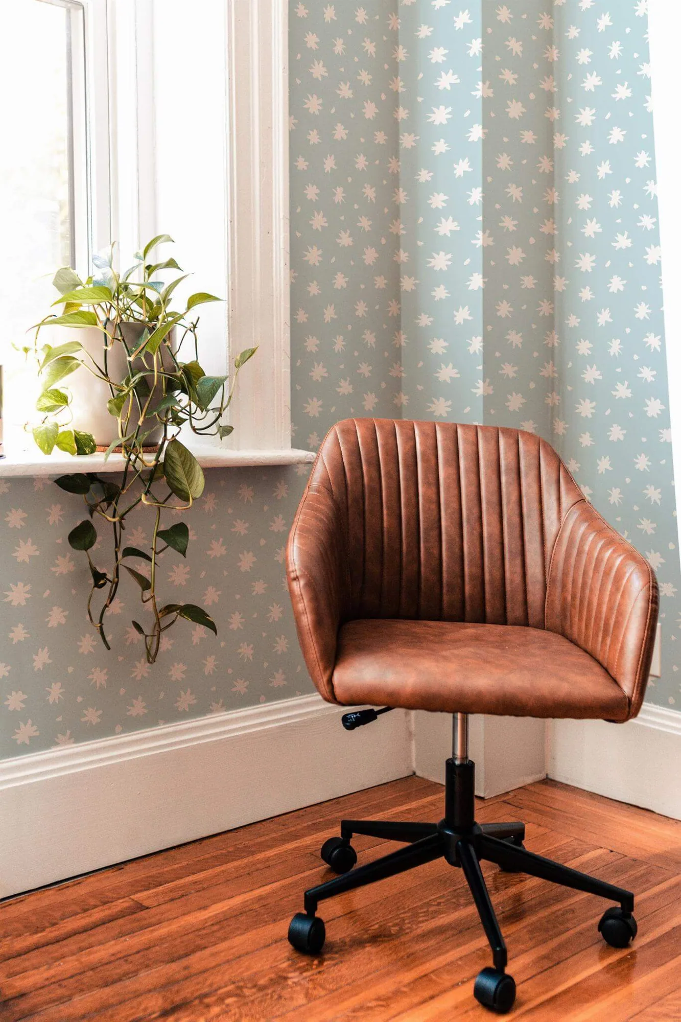 Minimalist floral wallpaper in a room setting: loose blue-and-white flower marks in a small printed repeat
