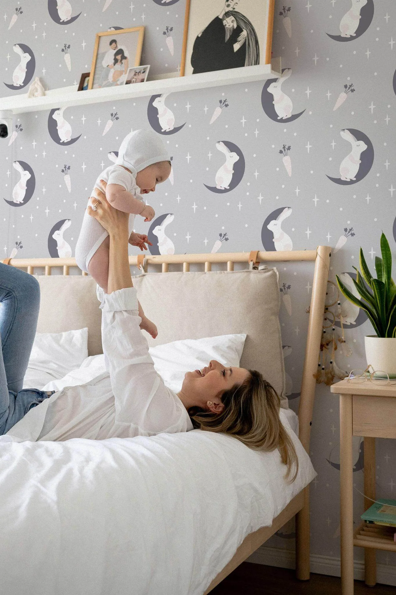 Moon and bunny nursery wallpaper in a room setting: rabbits resting on crescent moons with stars, in soft gray and white