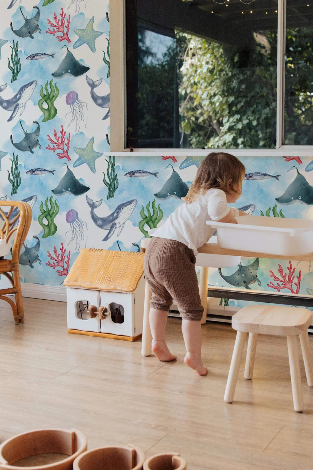 Ocean life wallpaper in a room setting: watercolor fish and sea plants in easy blues and greens