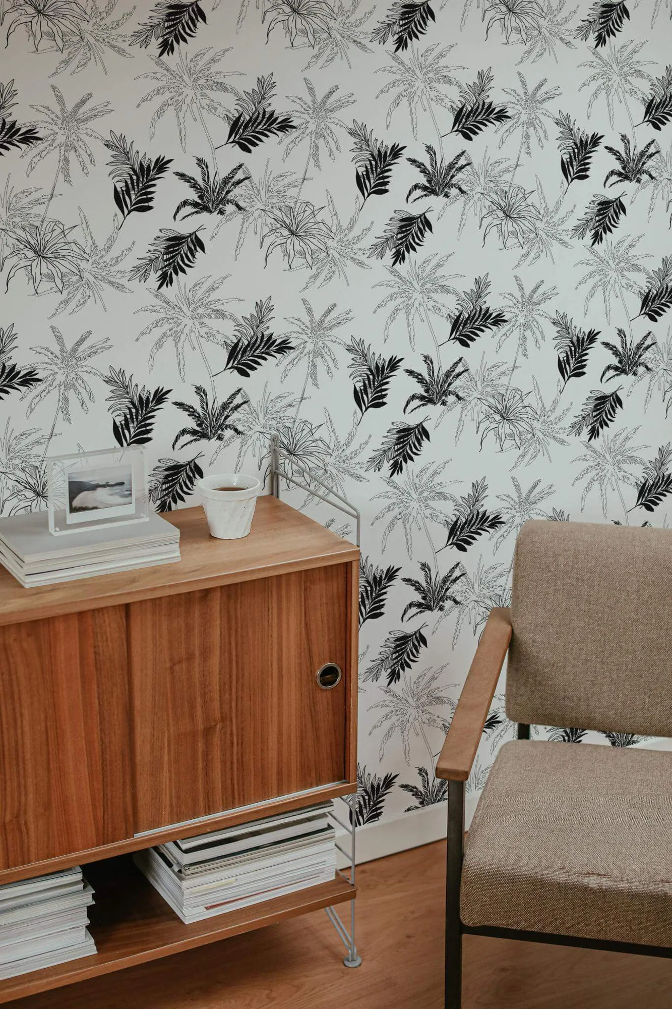 Palm wallpaper in a room setting: black palm fronds and fine sketched foliage on white