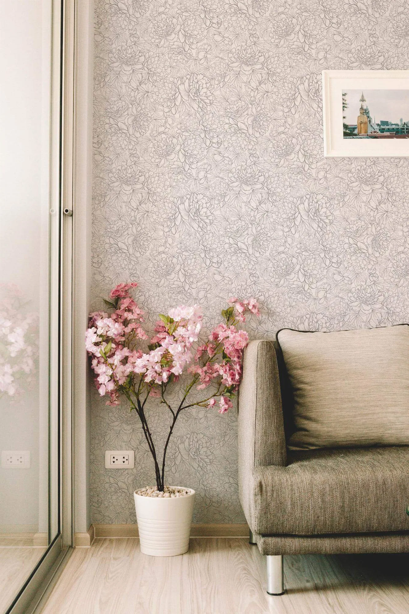 Peony floral wallpaper in a room setting: black peonies and fine leafy stems on white in a dense printed repeat