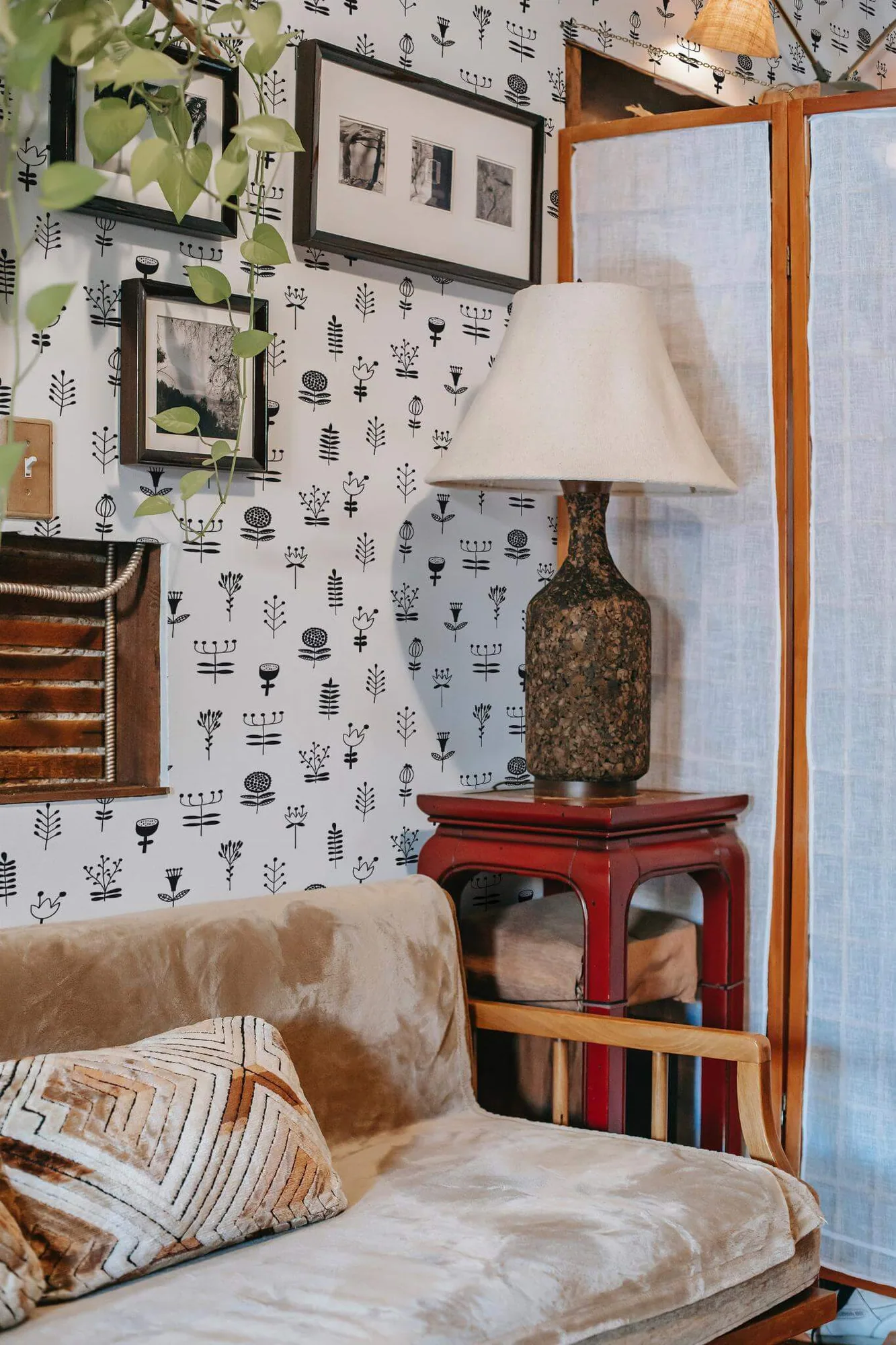 Scandinavian floral nursery wallpaper in a room setting: small black line-drawn flowers and stems are spaced across white